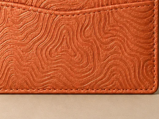 Close-up of the embossed pattern on the Cosmic Orange cardholder